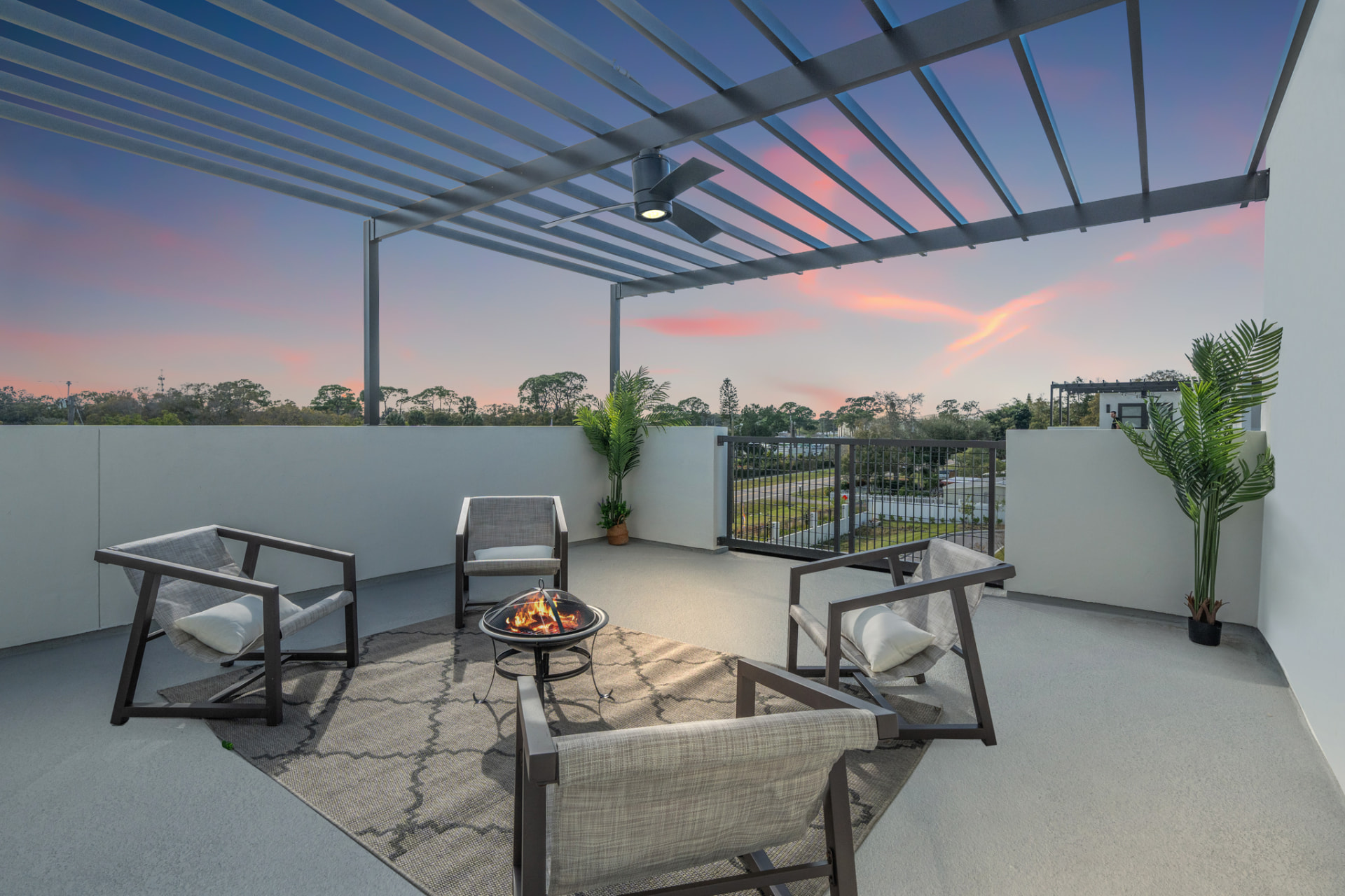 Firepit lounge under a pergola at sunset on a private rooftop terrace in Pinellas Park FL