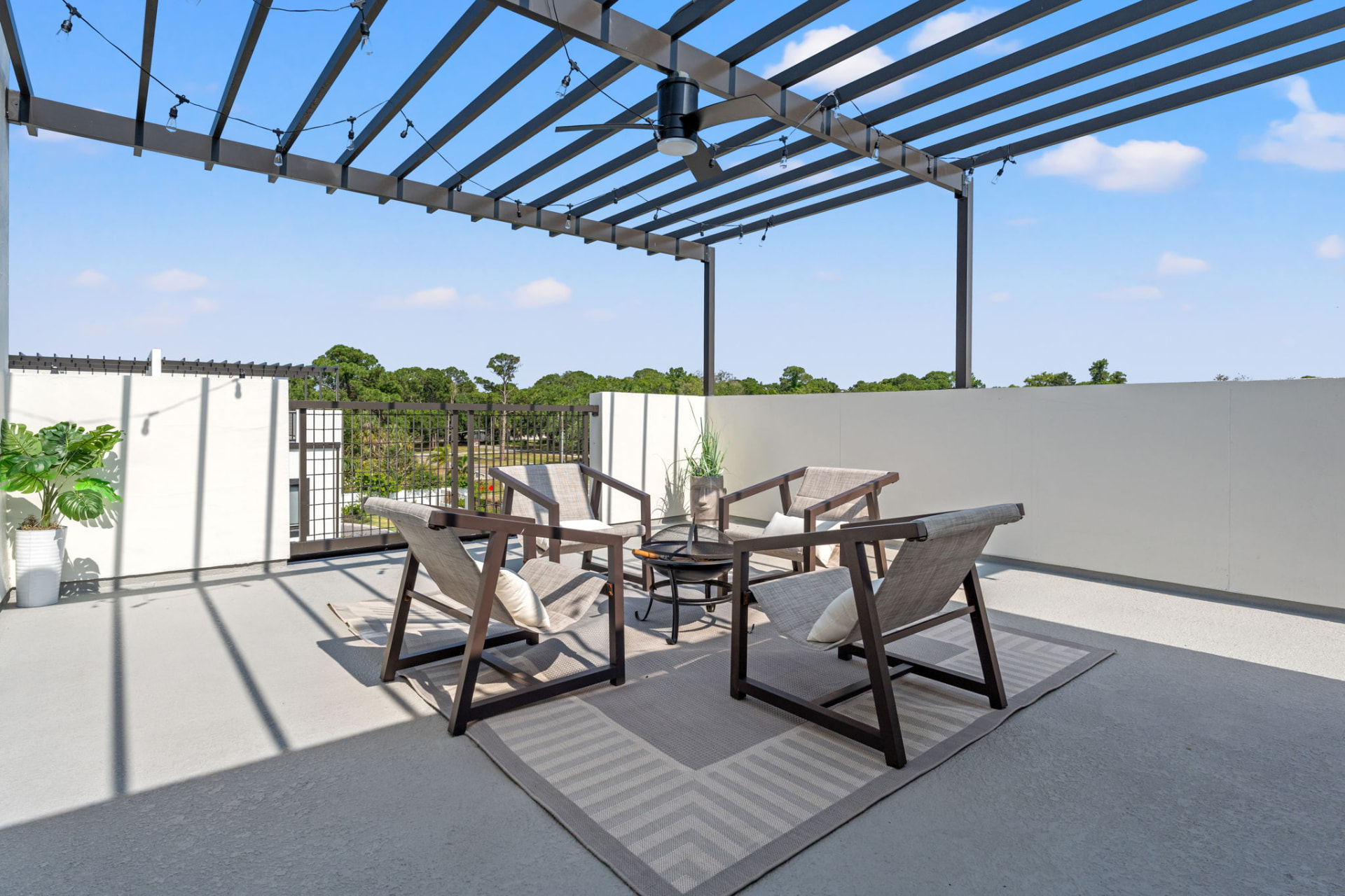 Shaded lounge chairs beneath the steel pergola on an engineered third level at Latitudes in the Park, Pinellas Park FL