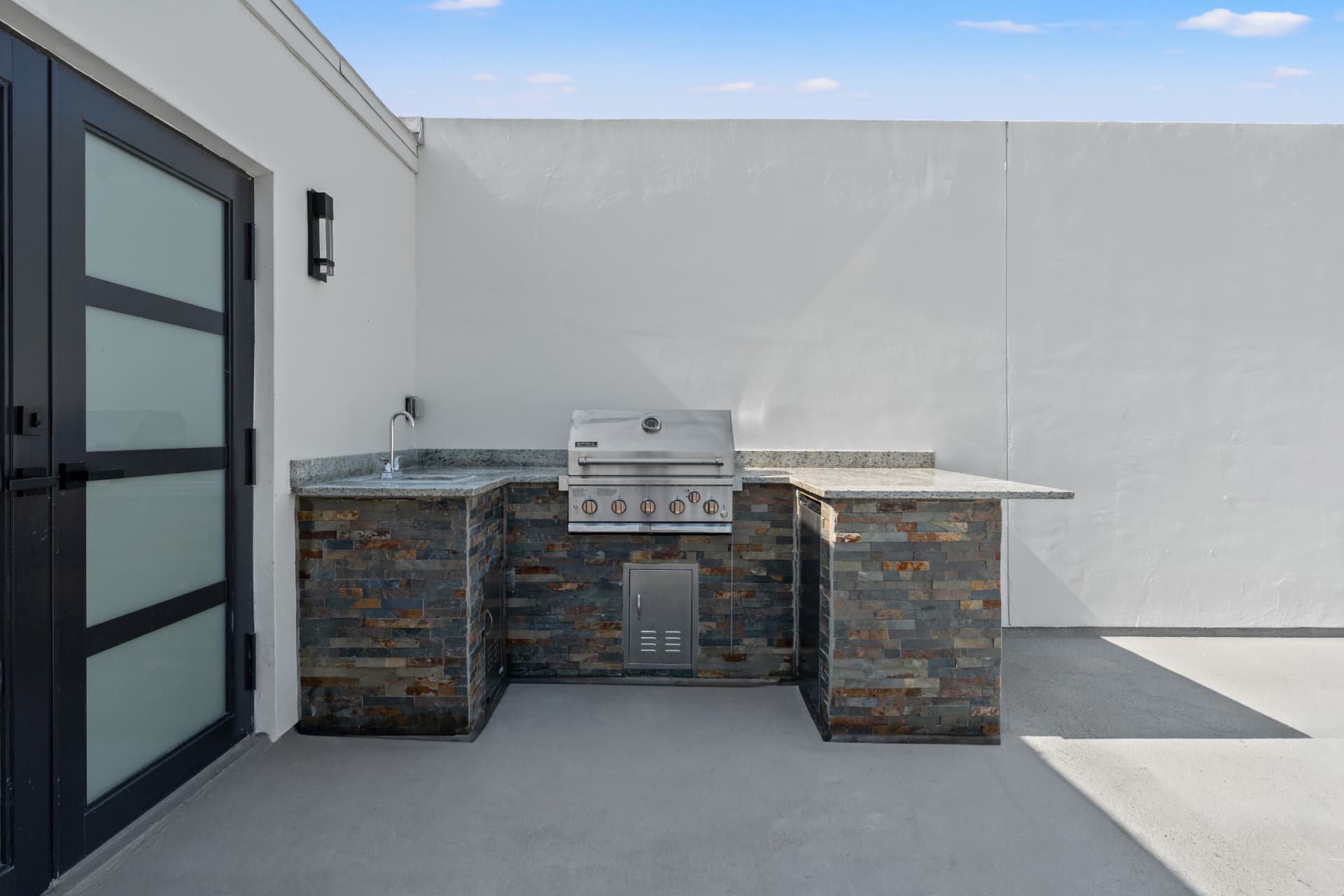 Built-in grill station with stone counter on a premium corner rooftop at Latitudes in the Park, Pinellas Park FL