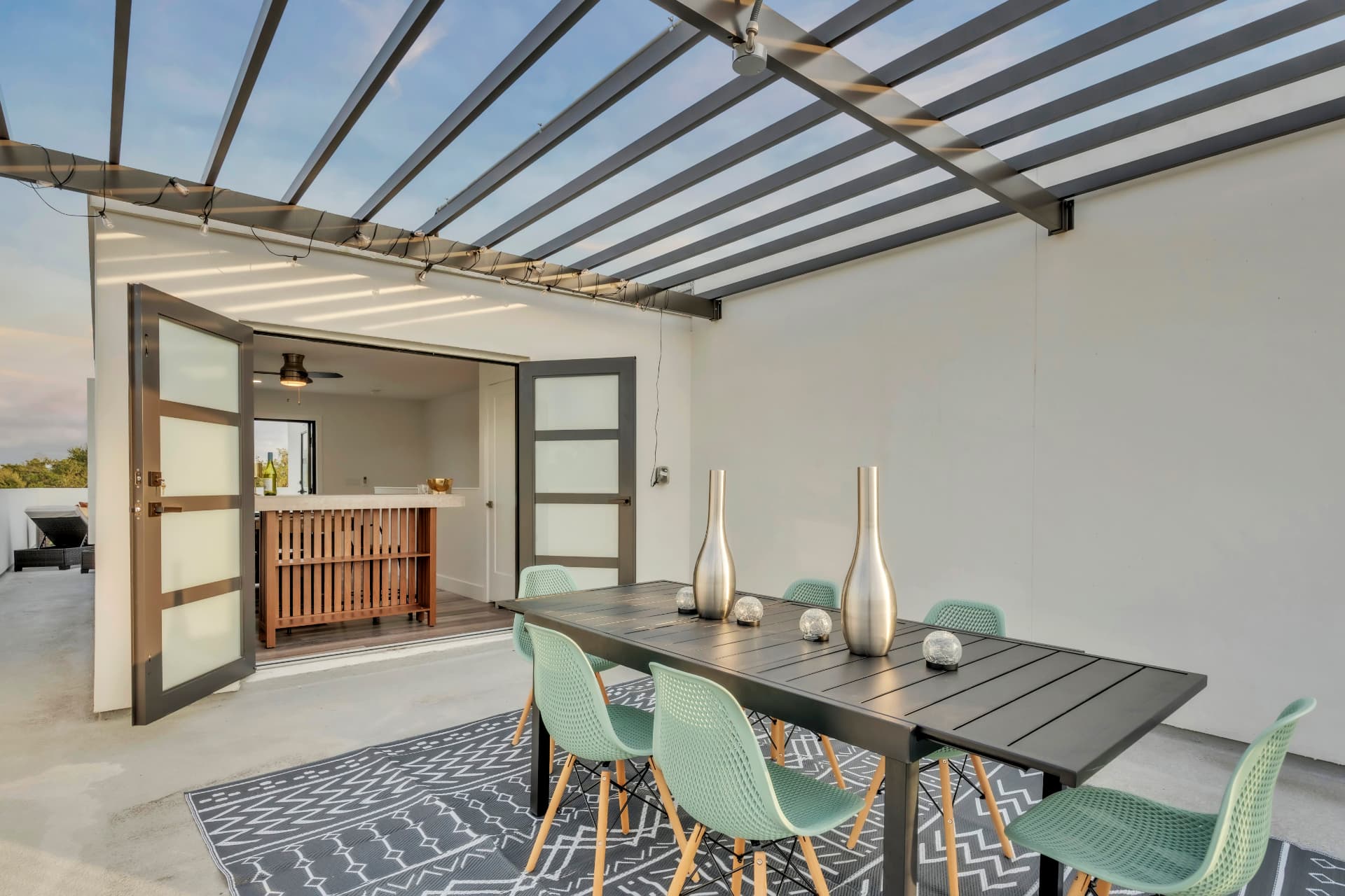 Rooftop dining table set for six beneath a steel pergola at Latitudes in the Park, Pinellas Park FL