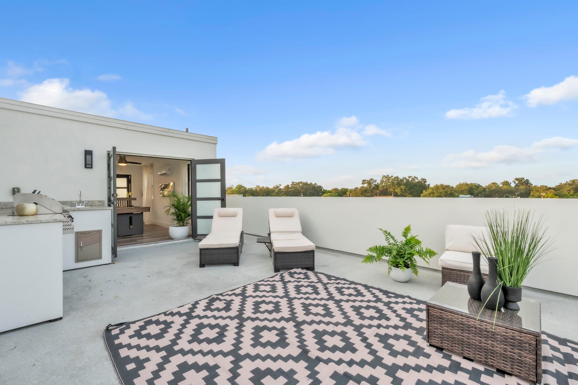 Loungers on an open rooftop deck under a wide blue sky on a private rooftop terrace at Latitudes in the Park, Pinellas Park FL